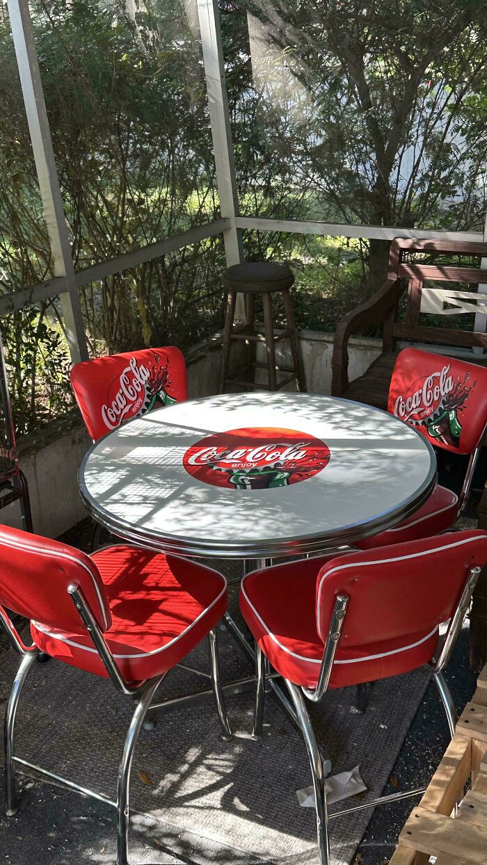 Vintage Coca-Cola round table with matching red chairs in thrifted setup