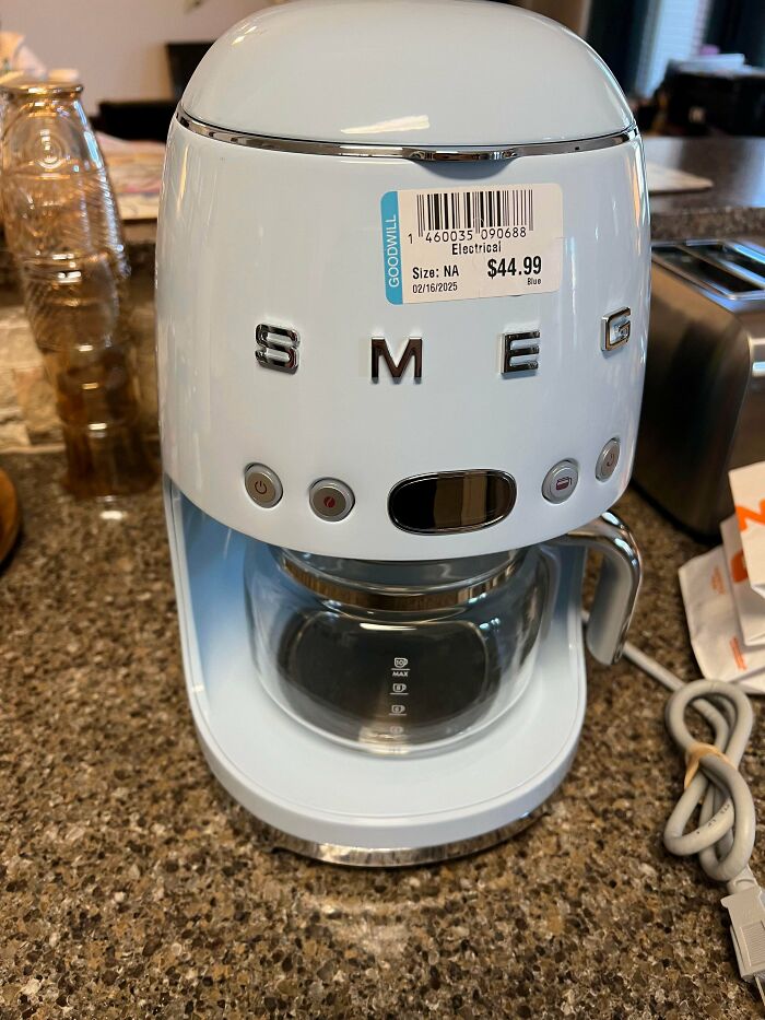 White SMEG coffee maker with Goodwill price tag on kitchen counter