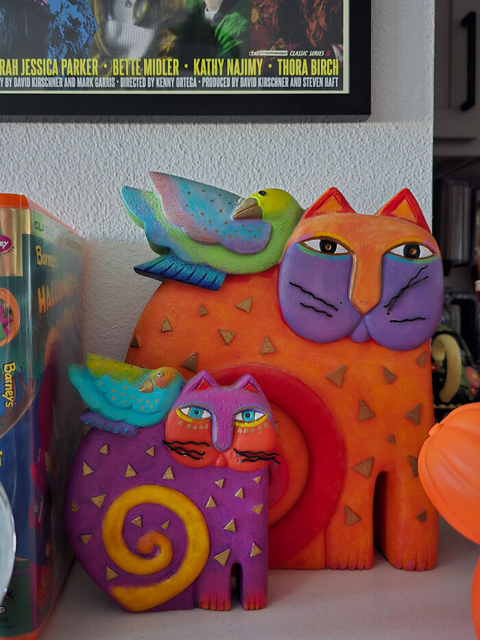Colorful cat and bird figurines displayed with other items from a Goodwill find