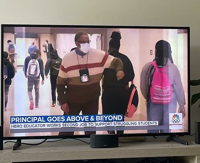 Principal helping students on TV news highlighting dystopia theme