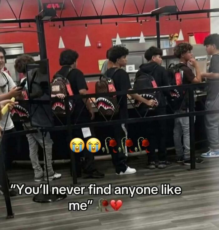Group of young men in line wearing matching shark design backpacks