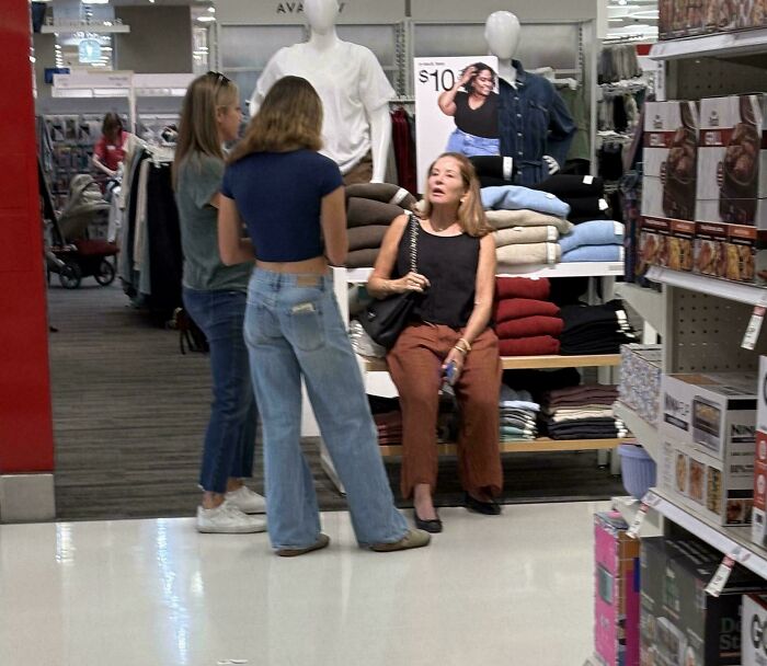 Customers chatting near clothing display inside retail store
