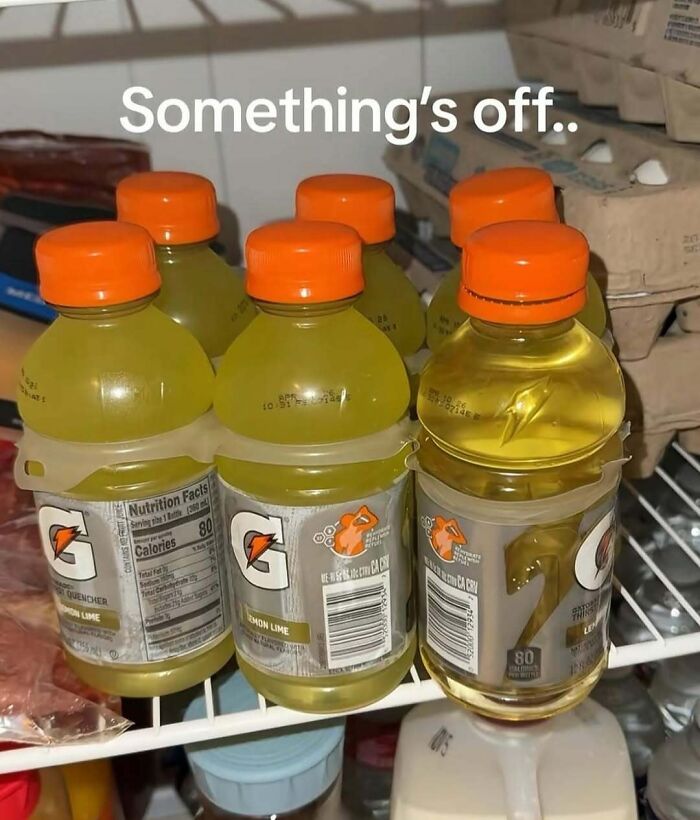 Gatorade bottles with one clear bottle looking off in a fridge showing random sense of humor