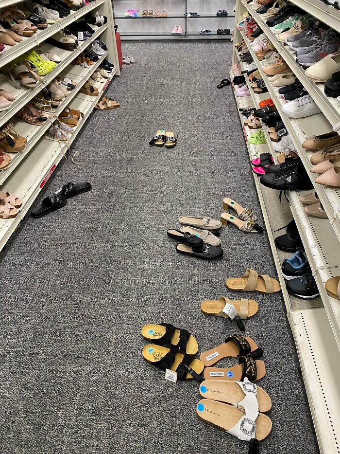 Untidy shoe aisle in retail store with many shoes scattered on the floor
