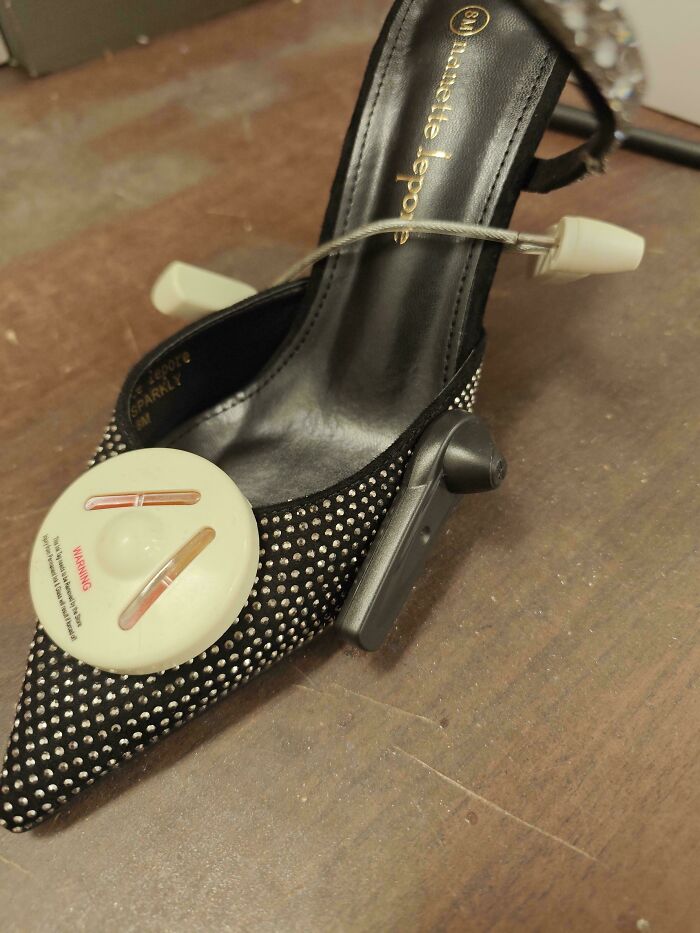 Retail shoe with attached anti-theft security tag on display table