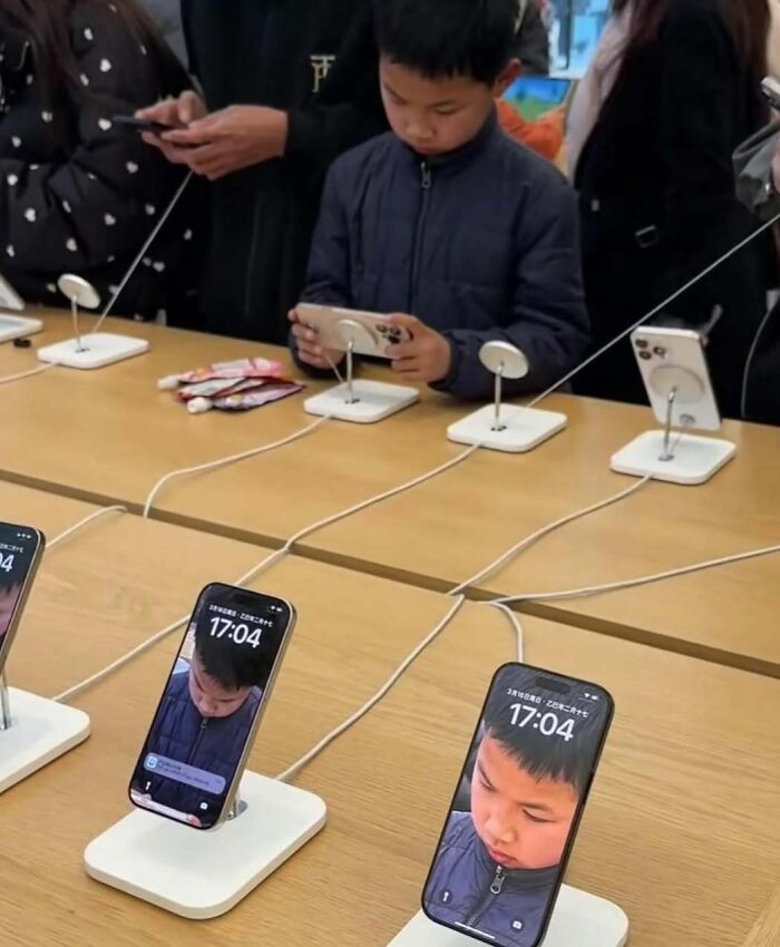 Child playing with a smartphone at an electronic store