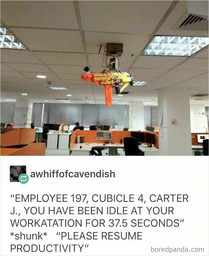 Office with ceiling toy gun and message about work productivity in dystopia