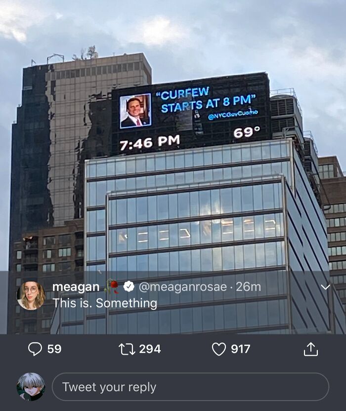Digital billboard showing curfew announcement at 8 PM with tweet comment