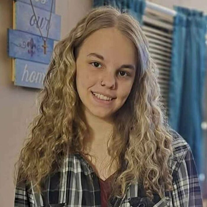 Young woman with curly blonde hair smiling in a casual horror stories photo