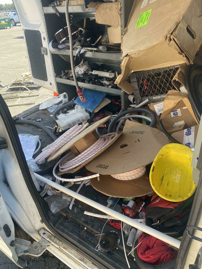 Messy work van filled with tools and boxes showing workplace disorganization