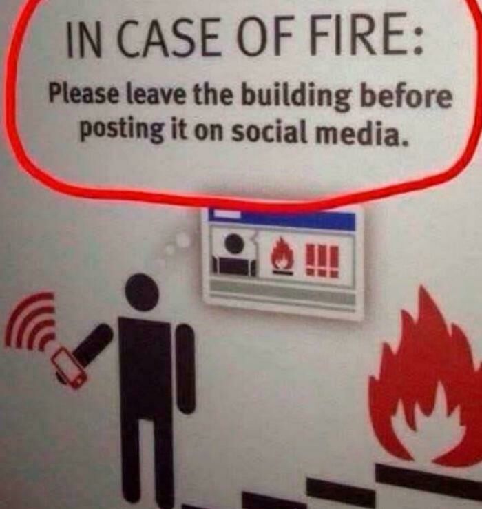 Funny fire safety sign advising to leave before posting on social media