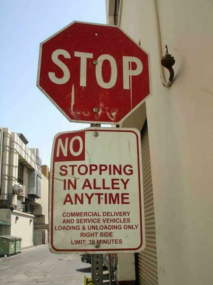 Confusing stop and no stopping signs posted together in alley