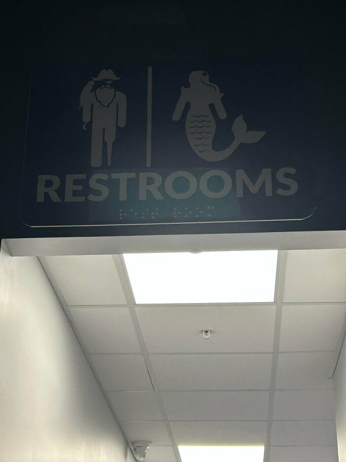 Creative restroom sign showing fisherman and mermaid icons