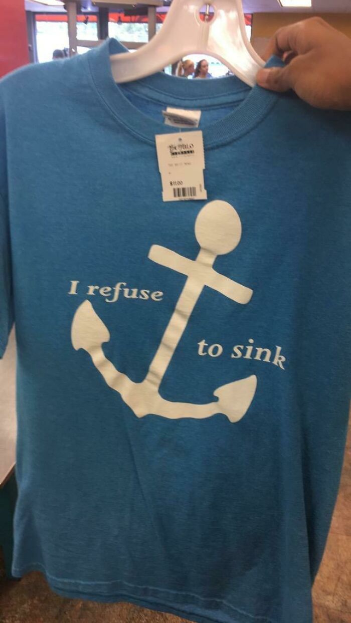 A blue t-shirt with a white anchor graphic and the text 'I refuse to sink,' an example of bad clothing design.