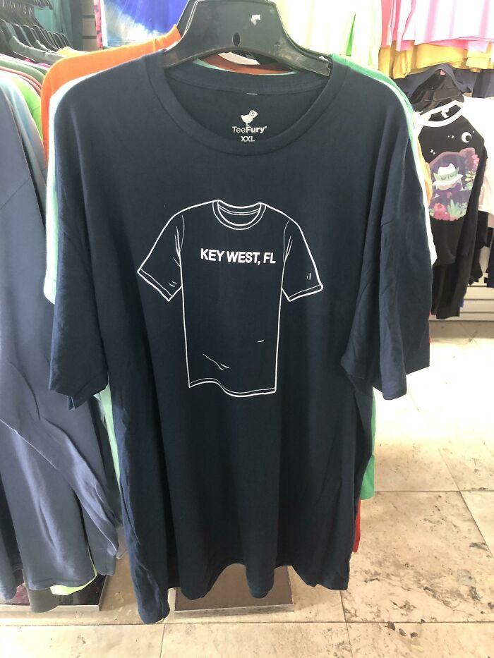 Clothing design: A dark blue t-shirt hanging on a rack, featuring a simple outline of a t-shirt and the text KEY WEST, FL.