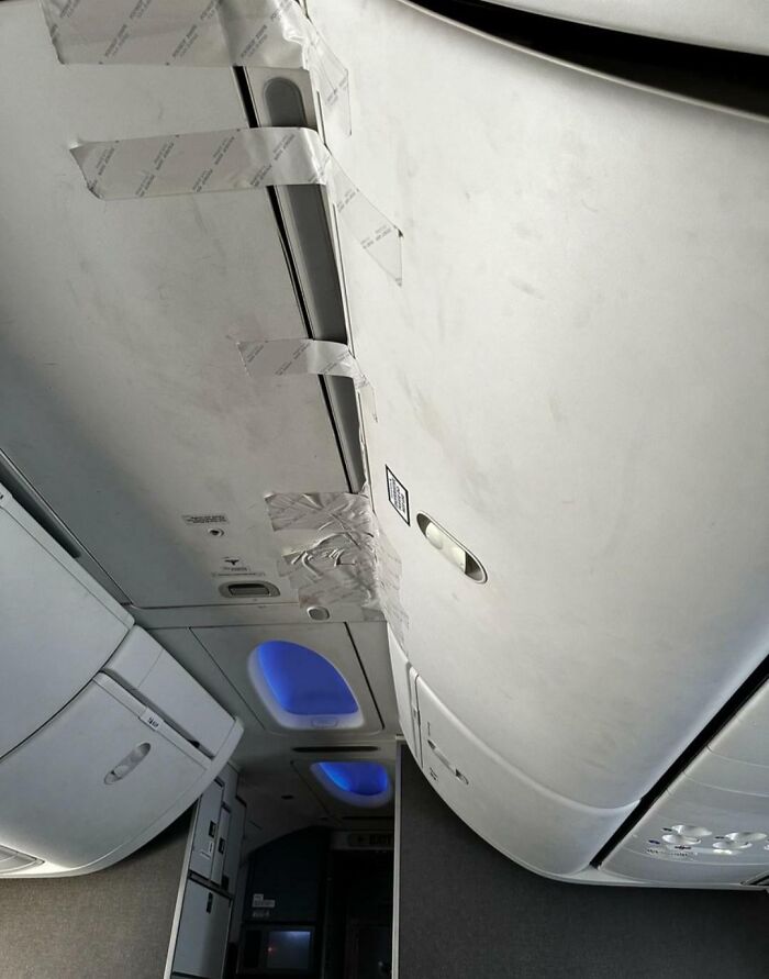 Airports scene: airplane overhead compartments clumsily secured with silver tape, indicating a chaotic and unsafe situation.