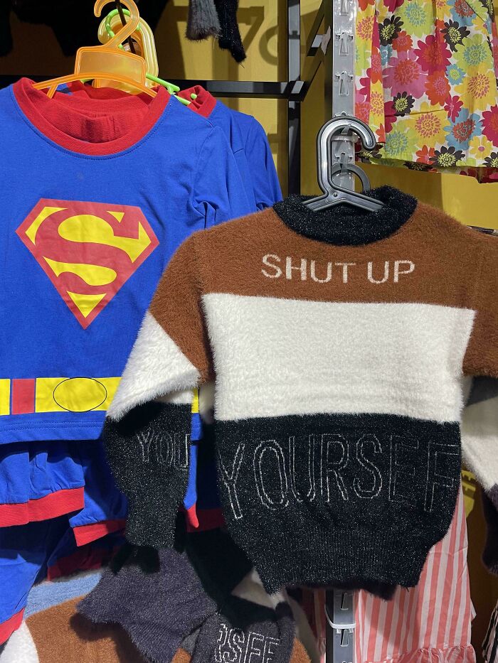 Superman shirt next to a fuzzy sweater with 'SHUT UP YOURSELF' on it, an example of bad clothing designs.