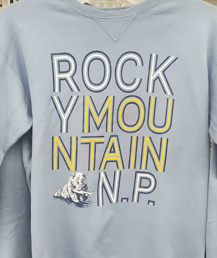 Light blue sweatshirt with ROCKY MOUNTAIN N.P. text and a bear, showcasing bad clothing designs.