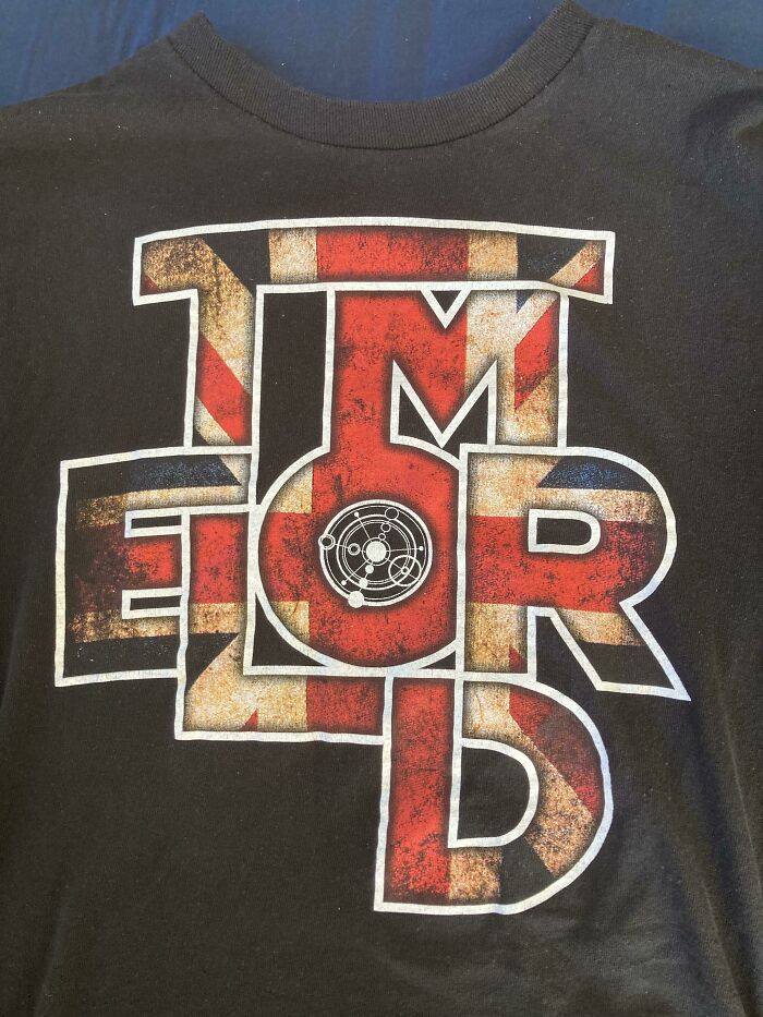 A black t-shirt with the word 'TMEORD' in a British flag pattern. An example of bad clothing designs.