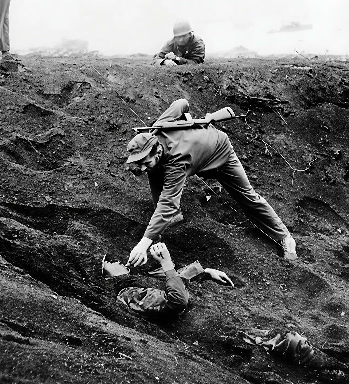 Black and white WWII soldier helping wounded comrade in horror war scene