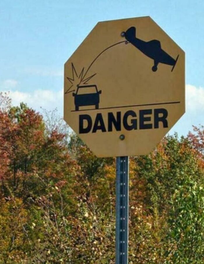 Danger sign depicting a plane crashing into a car in a humorous way