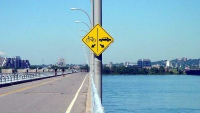 Confusing traffic sign showing bike and car paths diverging