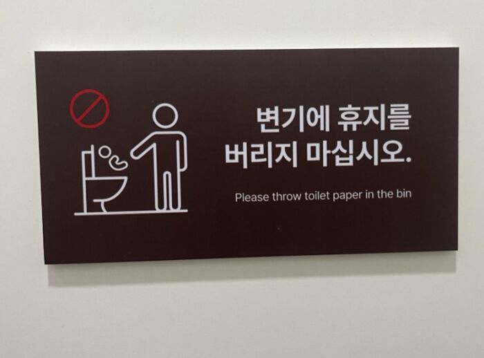 Funny toilet sign asking to throw paper in bin