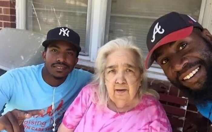 Two men with an elderly woman showing compassion and care