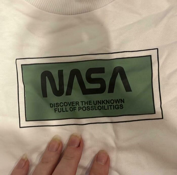 A white t-shirt with a green box containing a misspelled NASA logo. An example of bad clothing designs.