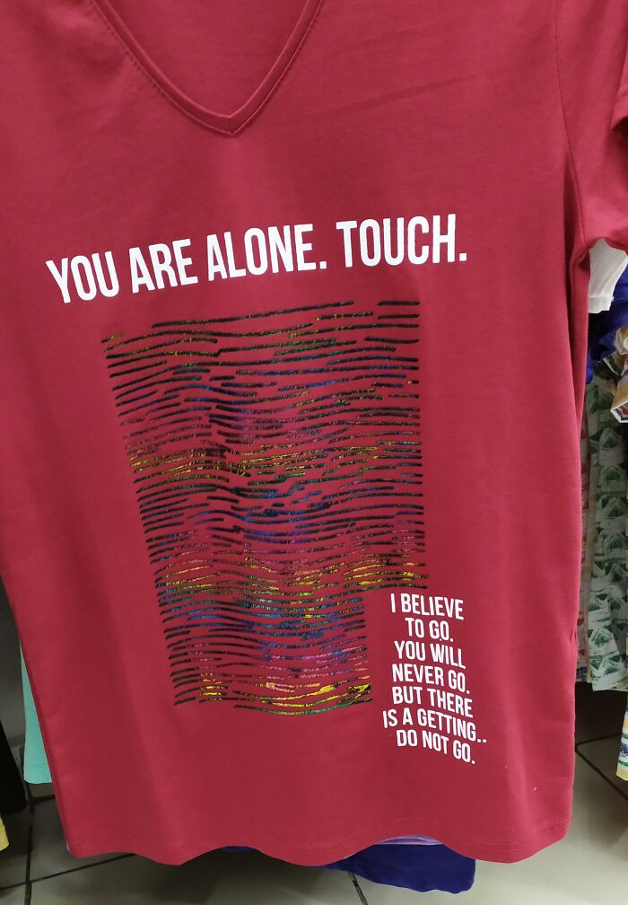 A red t-shirt with a complex graphic and grammatically incorrect phrases. An example of bad clothing designs.