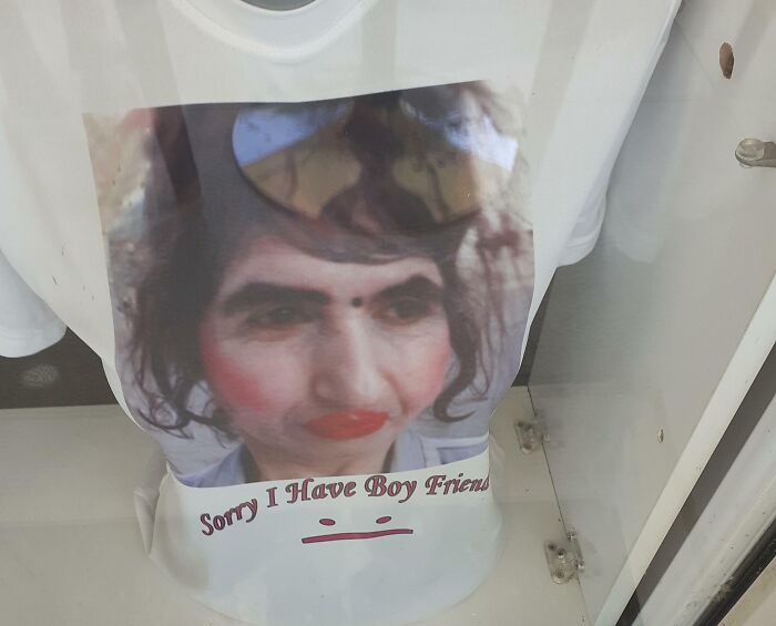A white T-shirt featuring a humorous image of a person with exaggerated makeup and the phrase Sorry I Have Boy Friends, a bad clothing design.