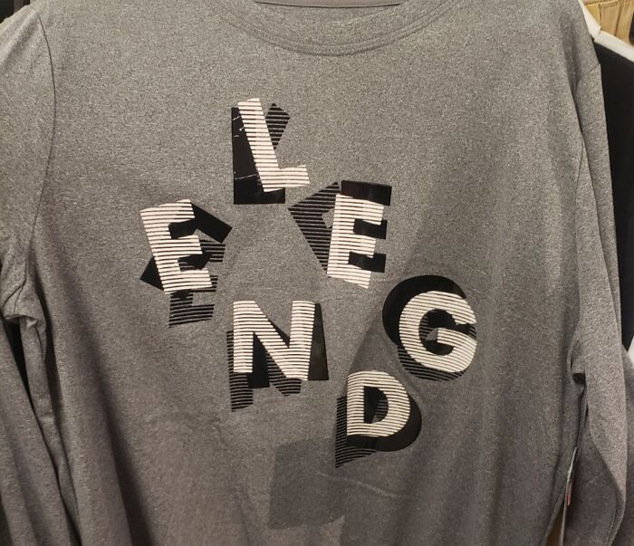 A grey long-sleeved shirt with the word LEGEND stylized awkwardly, part of a collection of bad clothing designs.