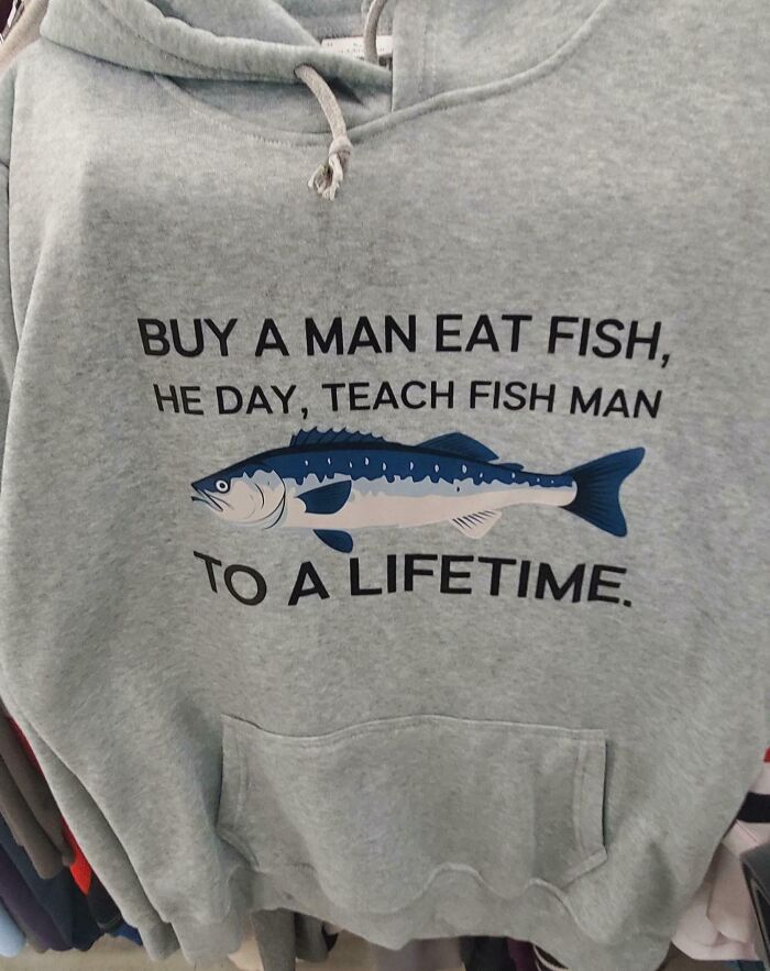 A grey hoodie with a nonsensical saying about fish and a fish graphic, representing bad clothing designs.