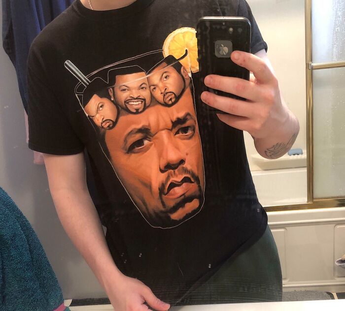 A man wearing a black t-shirt featuring a glass of iced tea made of Ice Cube's faces, showcasing bad clothing designs.