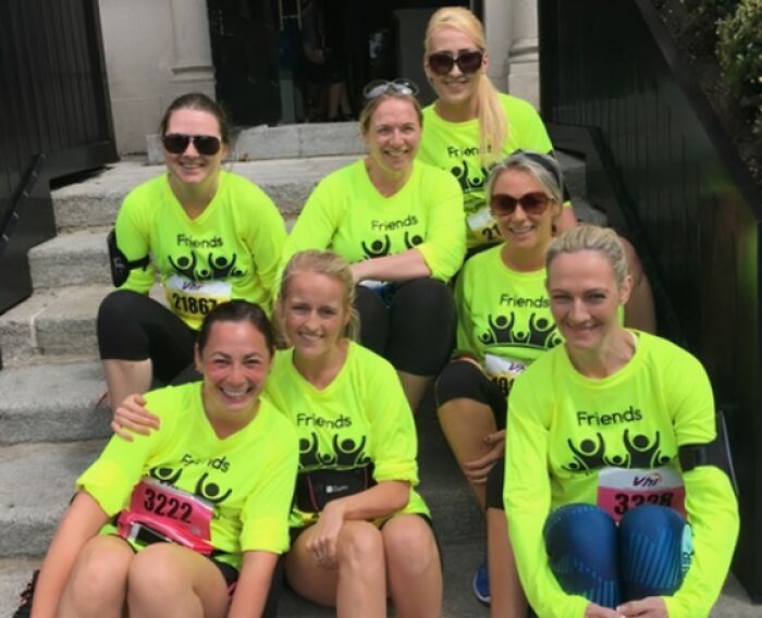 Seven women in bright yellow t-shirts with a 'Friends' logo, an example of clothing designs.