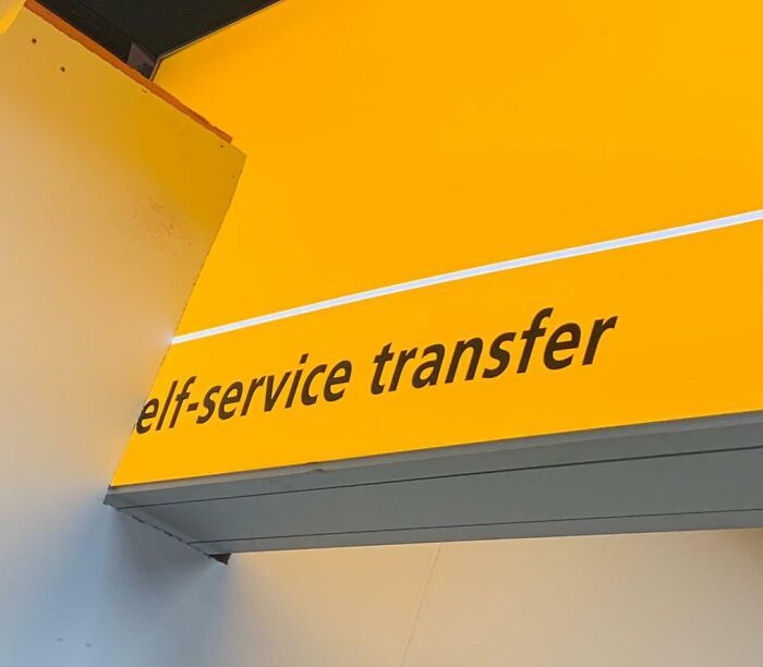 An airport sign reading elf-service transfer, indicating potentially chaotic self-service options at airports.