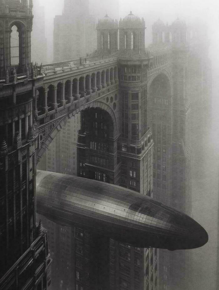 Urban hell gothic city with massive bridge and vintage airship in fog