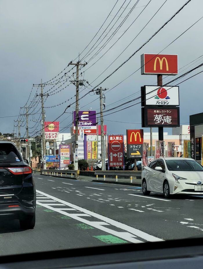 Traffic and commercial signs including McDonald's in urban hell cityscape