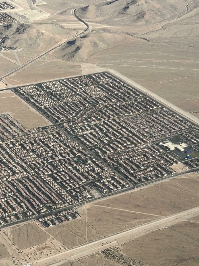 Suburban housing development in desert landscape from above urban hell