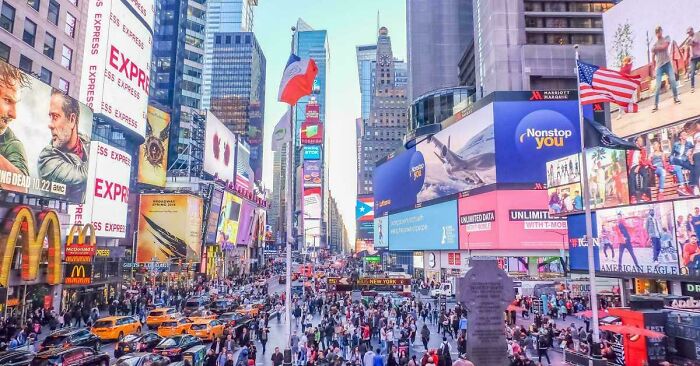 Crowded urban street filled with advertisements and heavy pedestrian traffic