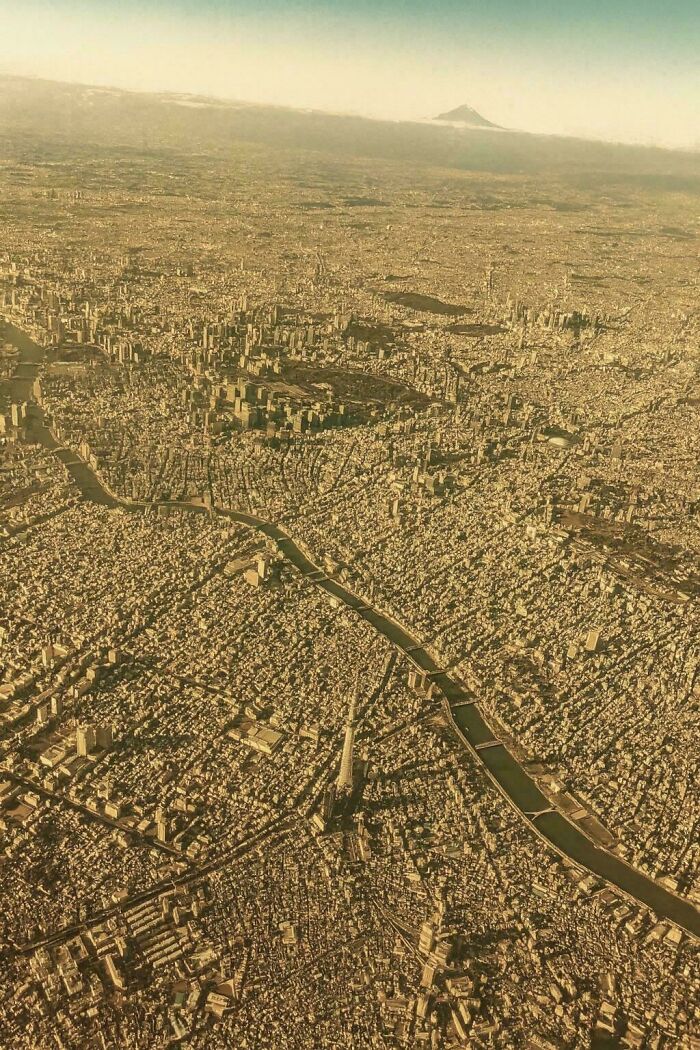 Aerial view of a densely populated urban cityscape with rivers and many buildings