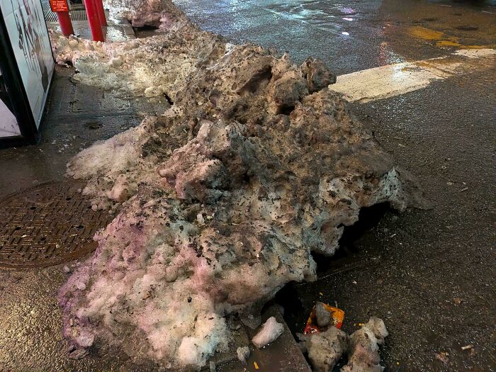 Dirty piles of melting snow on an urban street at night in urban hell conditions