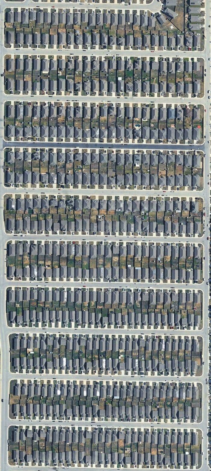 Aerial view of uniform suburban houses in a tightly packed neighborhood
