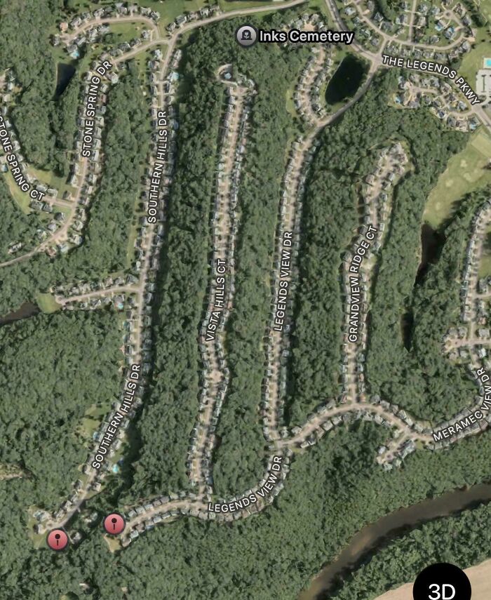Satellite view of suburban neighborhood with winding roads and dense trees