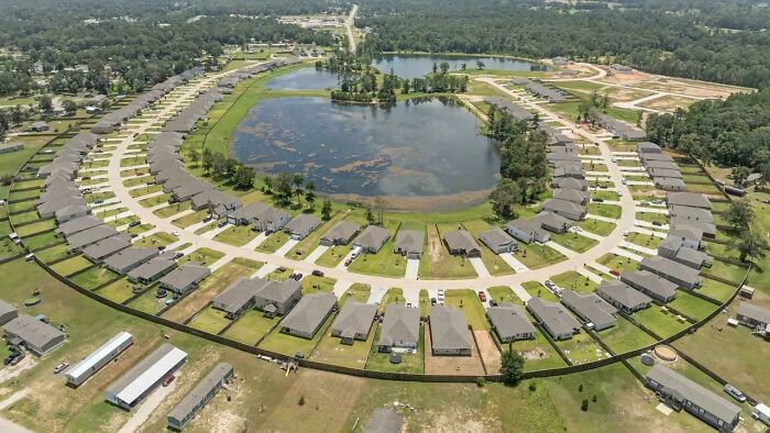 Aerial view of suburban housing development around a central pond