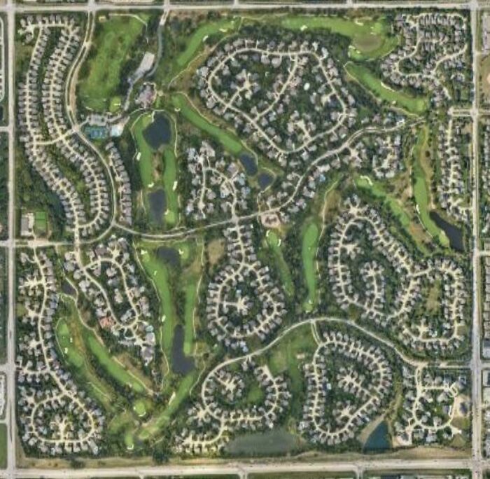 Aerial photo of upscale suburban neighborhood with golf course and large homes