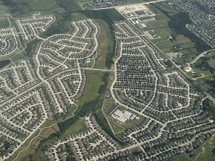 Aerial view of suburban neighborhood with dense housing and curved street patterns