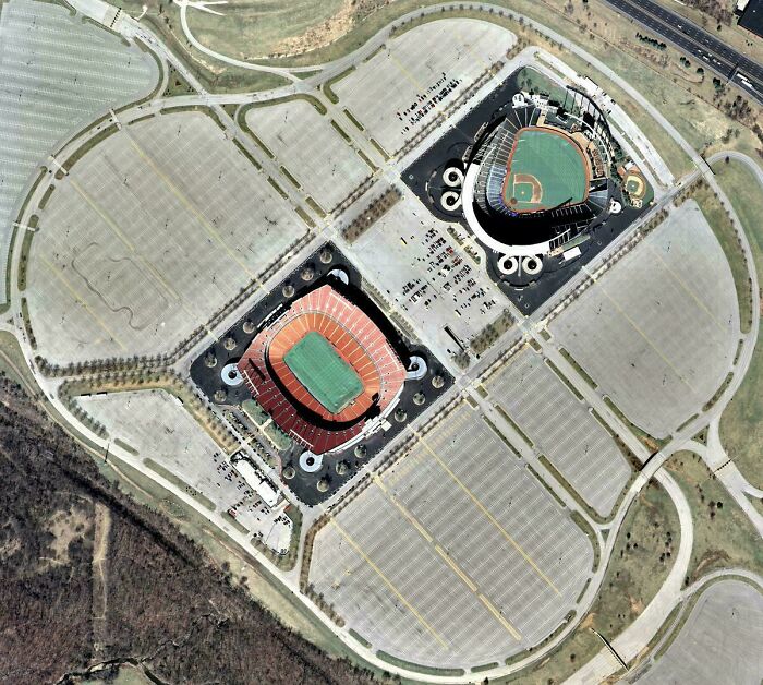 Aerial view of two large suburban stadiums surrounded by extensive parking lots