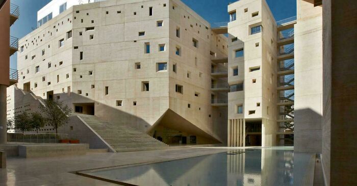 Brutalist concrete urban architecture with geometric shapes and reflecting pool