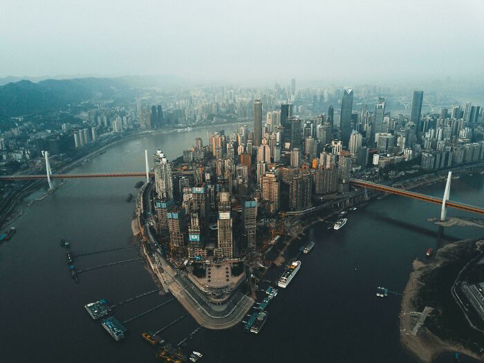 Aerial view of a city peninsula densely packed with skyscrapers and bridges